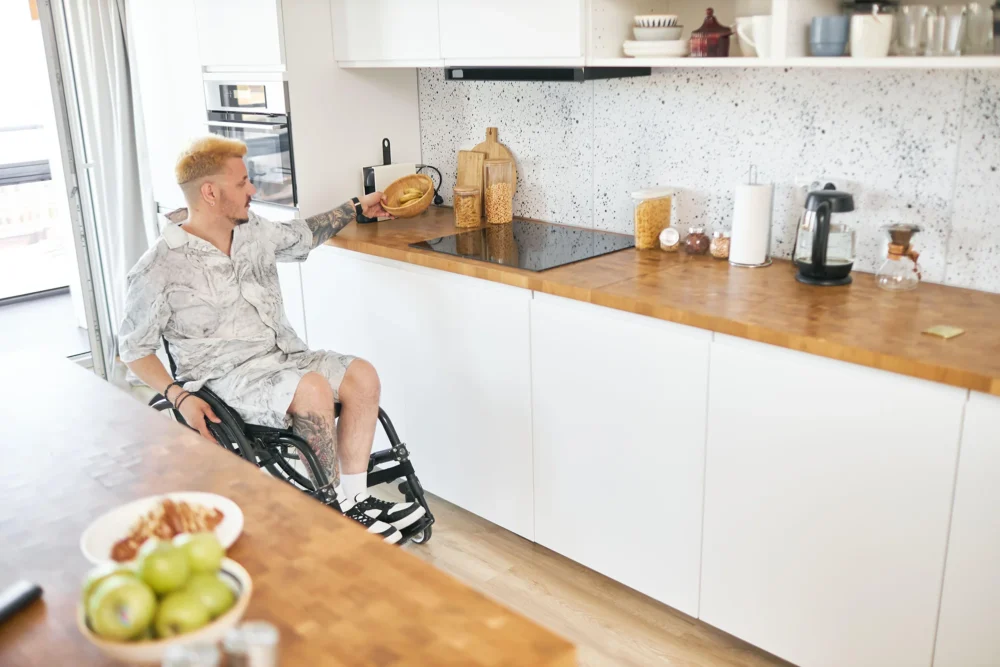 A wheelchair user in an accessible kitchen